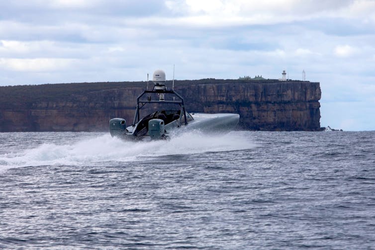 A photo of a speedboat powering through the water with nobody aboard.