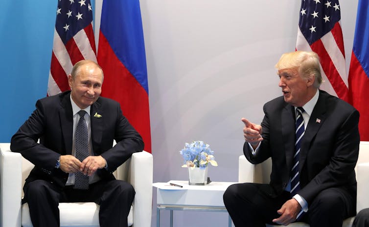 Vladimir Putin and Donald Trump sitting next to each other.