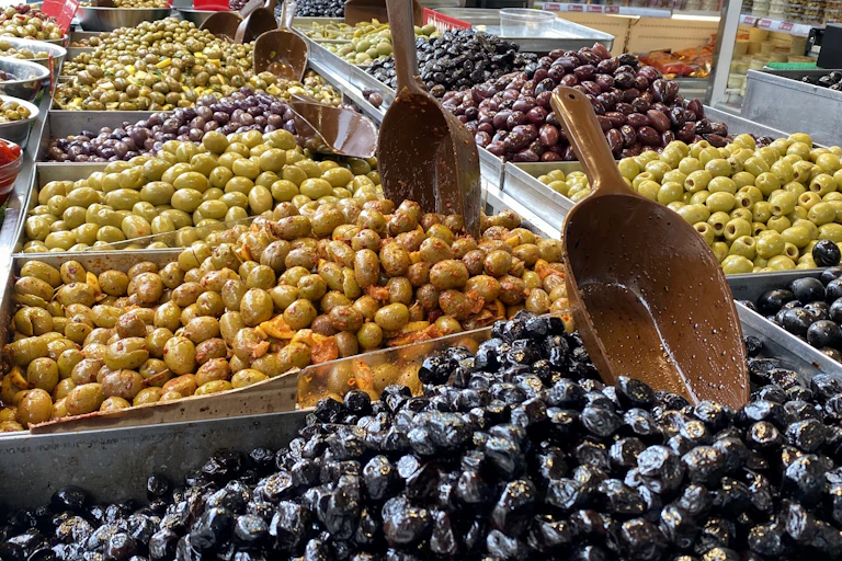 Collection of black and green olives at a market stand