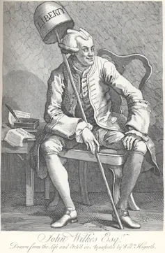 A black and white engraving by William Hogarth depicting John Wilkes holding a bell that reads 'liberty' and smiling demonically