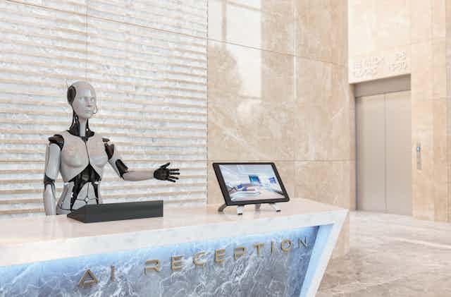 A robot stands at the reception desk of a hotel.