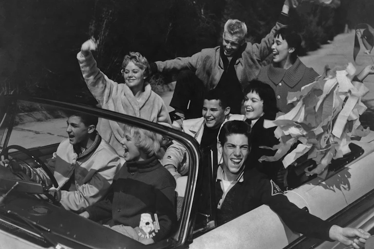 A group of teens in a convertible in the 1950s