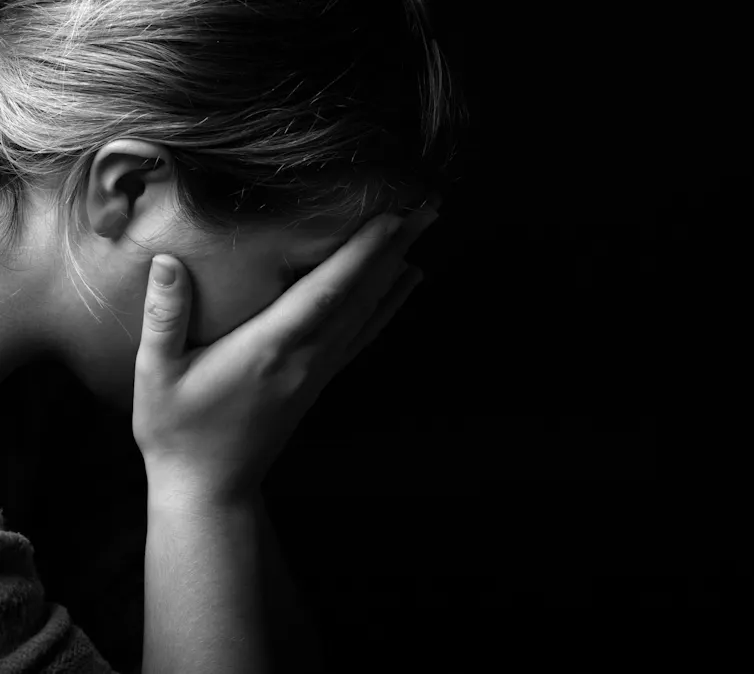 Black and white photo of a woman with her head in her hands