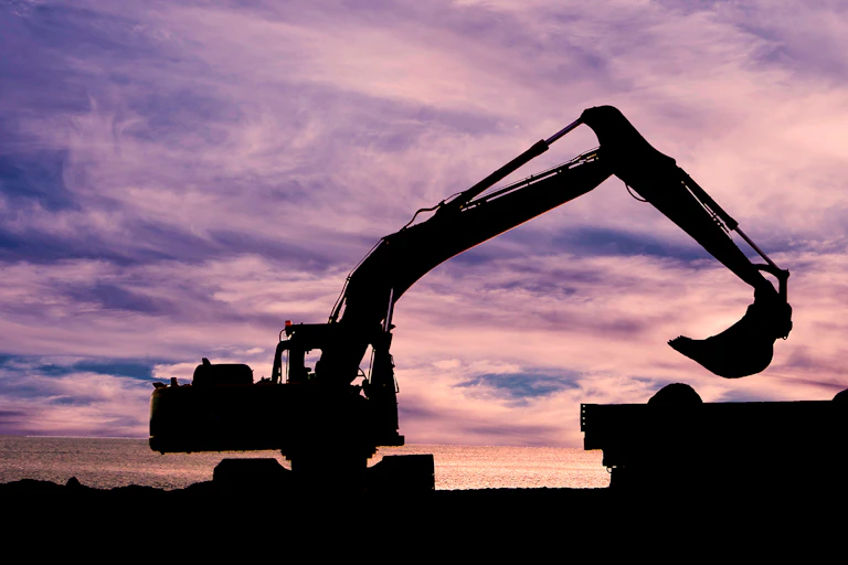 Mechanical digger in silhouette.