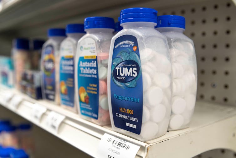 Bottles of antacids on a shelf at a pharmacy.