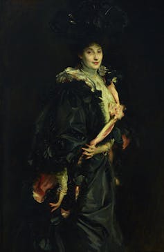 Lady Sassoon in a black cloak.