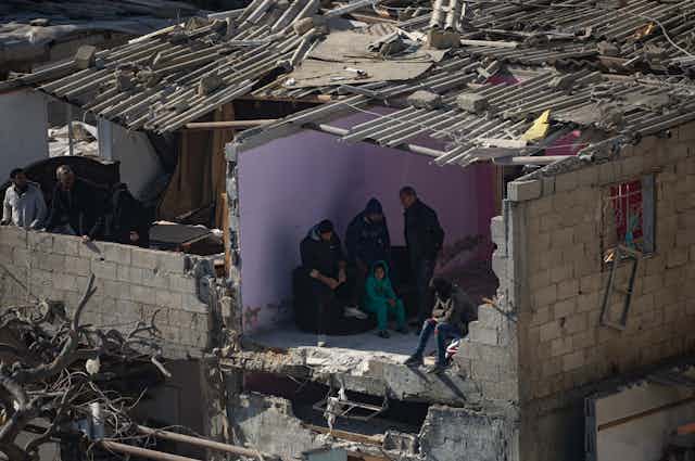Residents shelter in a half-destroyed house in Rafah refugee camp after Israeli airstrikes.