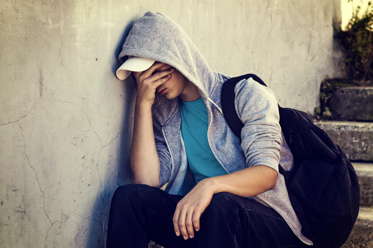 Sad teenage boy sat on steps