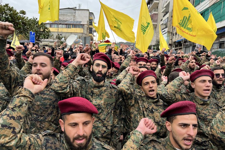 Hommes en uniforme et béret rouge avec des drapeaux du Hezbollah