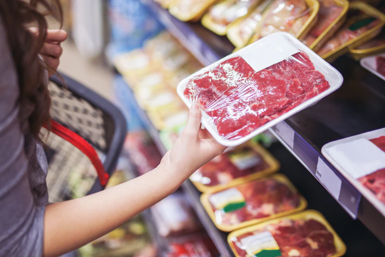 woman hold packet of red meat