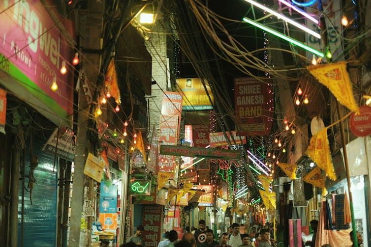 A market street with signs and lights at night.