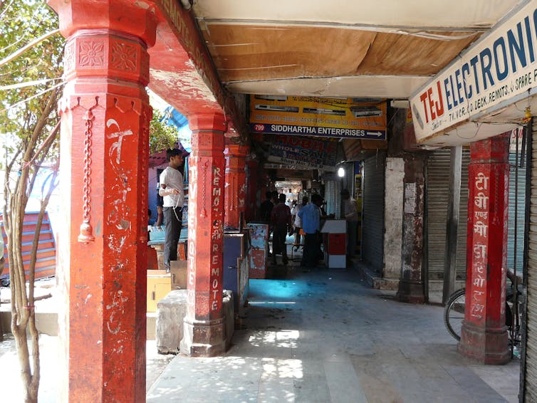A covered passageway in a market with red columns.