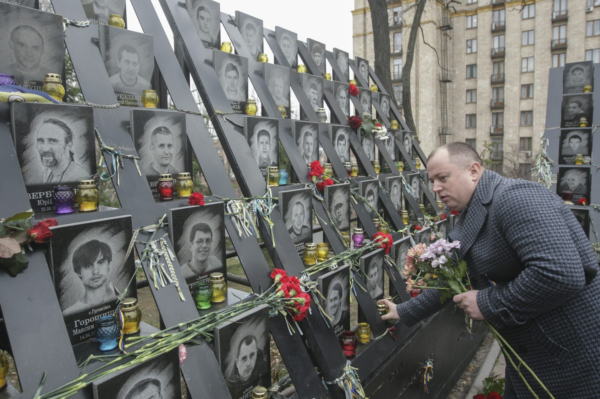 A man looks at pictures of people in a memorial to the Euromaidan protests of 2014 in Kyiv.