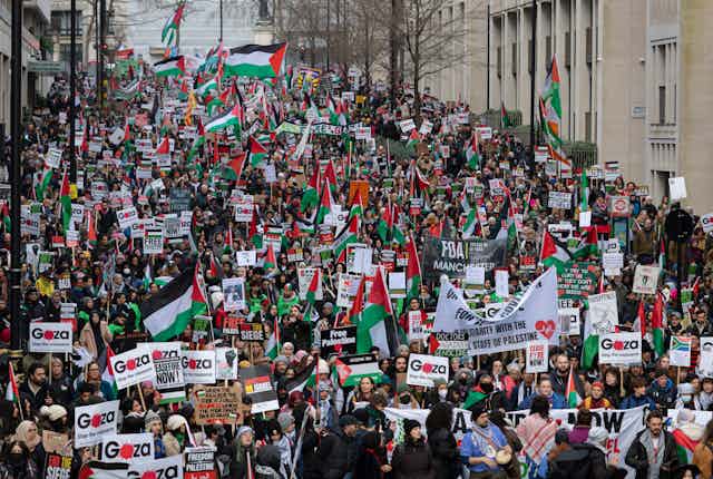 A large crowd of protesters carrying Palestinian flags fill a London street