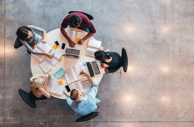 Students seen sitting at a round table.