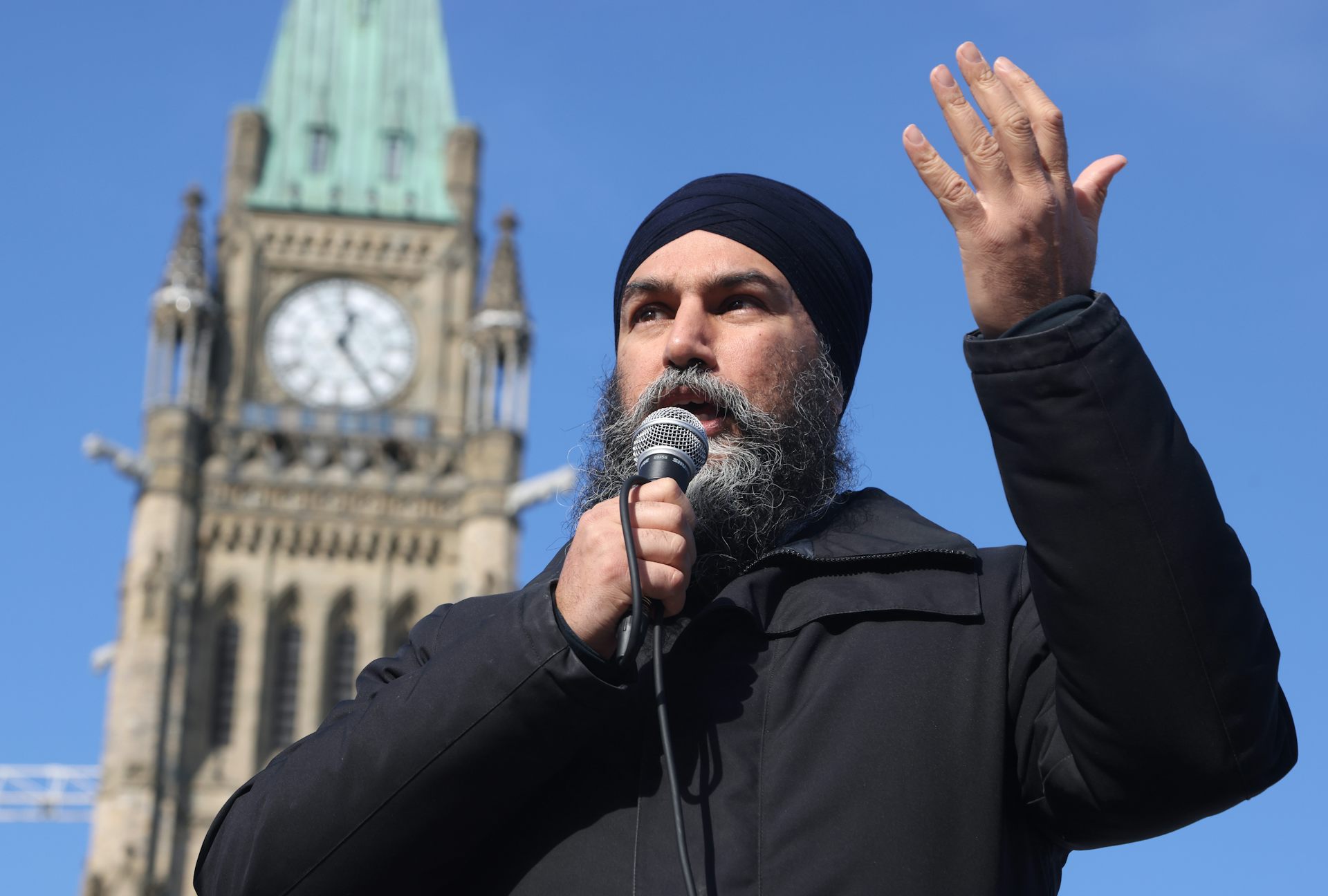 NDP leader Jagmeet Singh speaking outdoors with the Peace Tower in the background