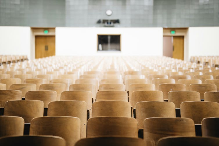 Rows of empty chairs in a theatre.