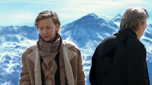 Film still: a man and a woman face away from each other