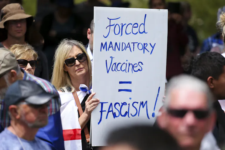 Woman holding anti-mandate protest sign