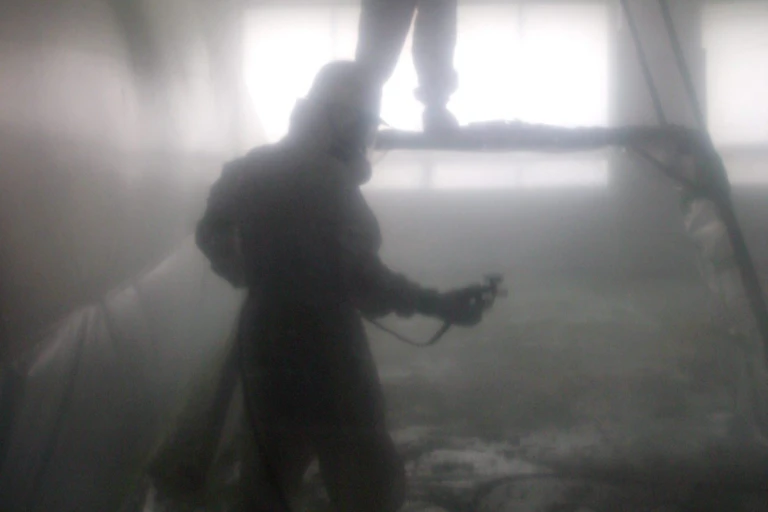People in protective clothing work in room containing asbestos