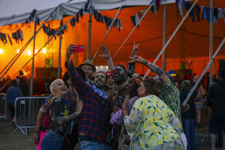 people taking a selfie at night at a music festival