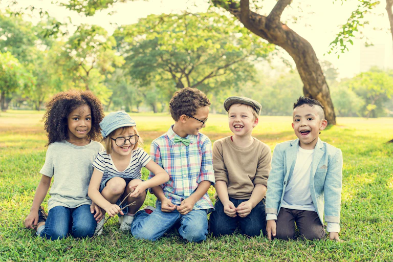 A group of children sitting on grass.