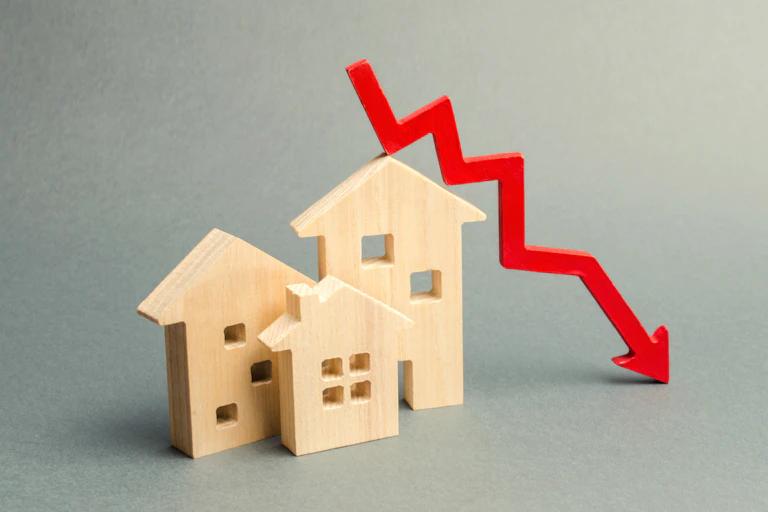 Small replica wooden houses superimposed with a red arrow pointing downwards.