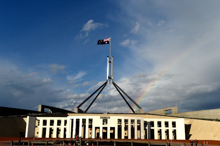 A rainbow beside the spire of Australia's Parliament House.