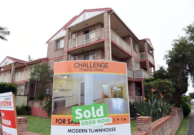 Multi storey block of townhouses with a "Sold'' real estate sign out the front.