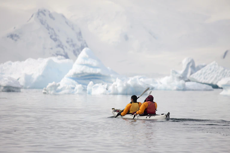 people kayaking in icy seas