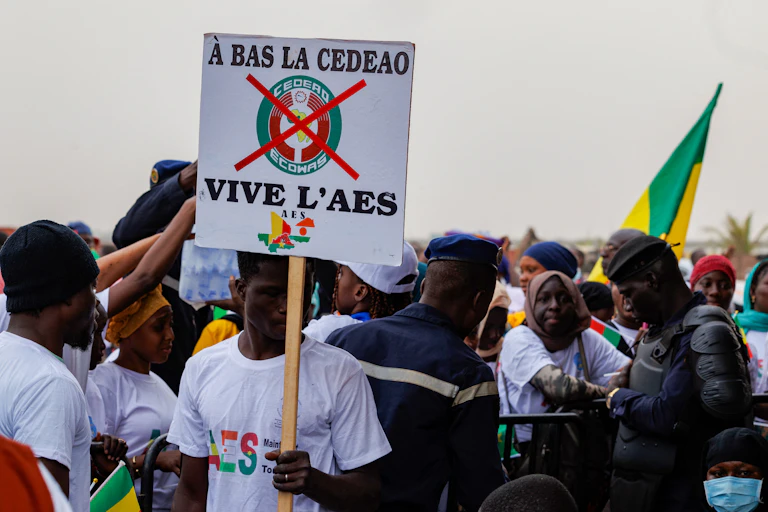 Man in white shirt holding a placard in protest