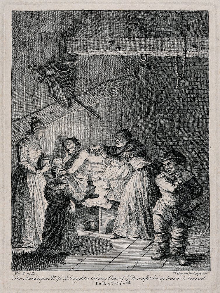 Black and white engraving of four people surrounding the bedside of a man lying prone, with one of the people tending to a wound on his back by candlelight