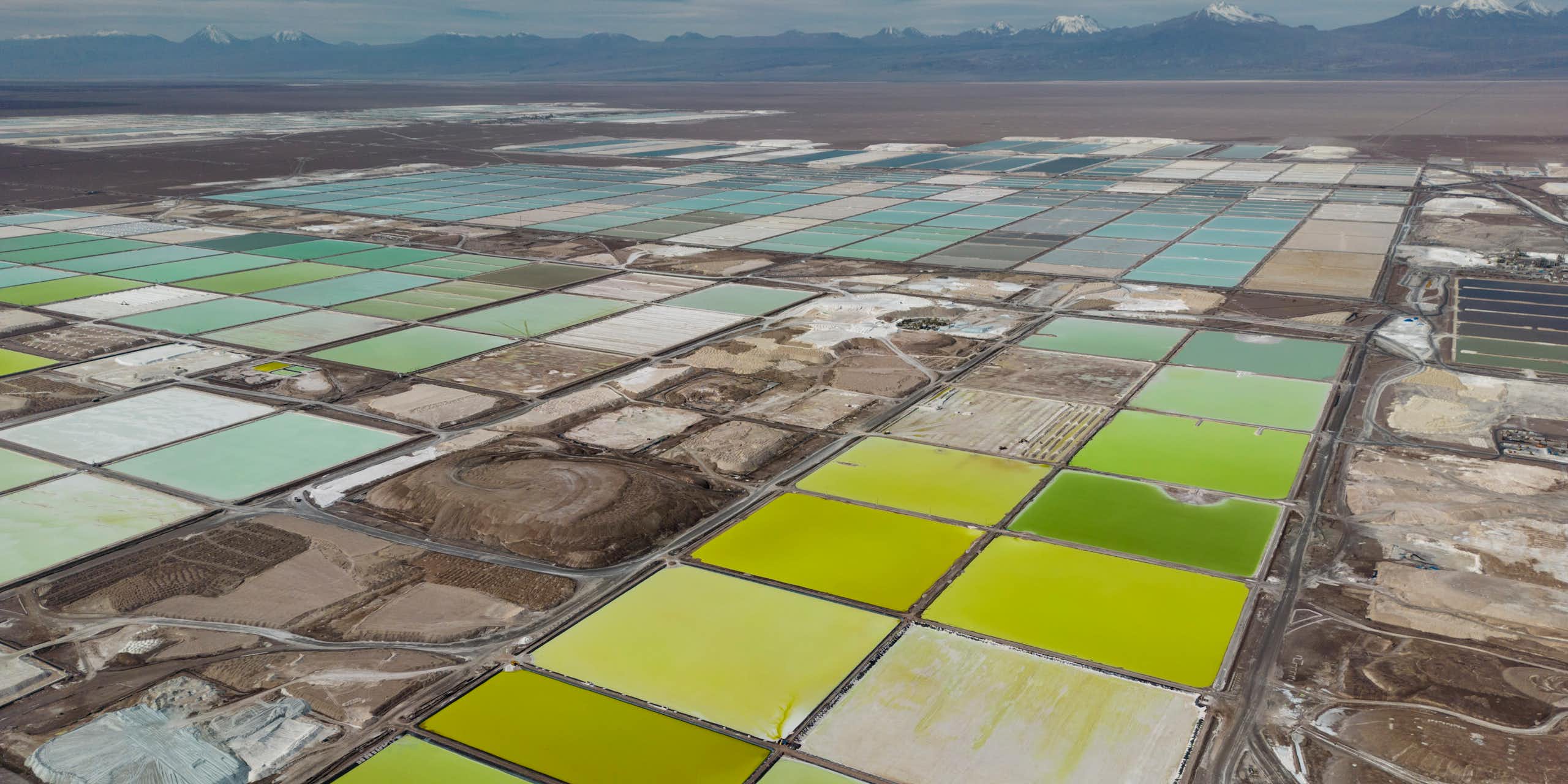 Pools of green and blue liquid is seen in an arid landscape.