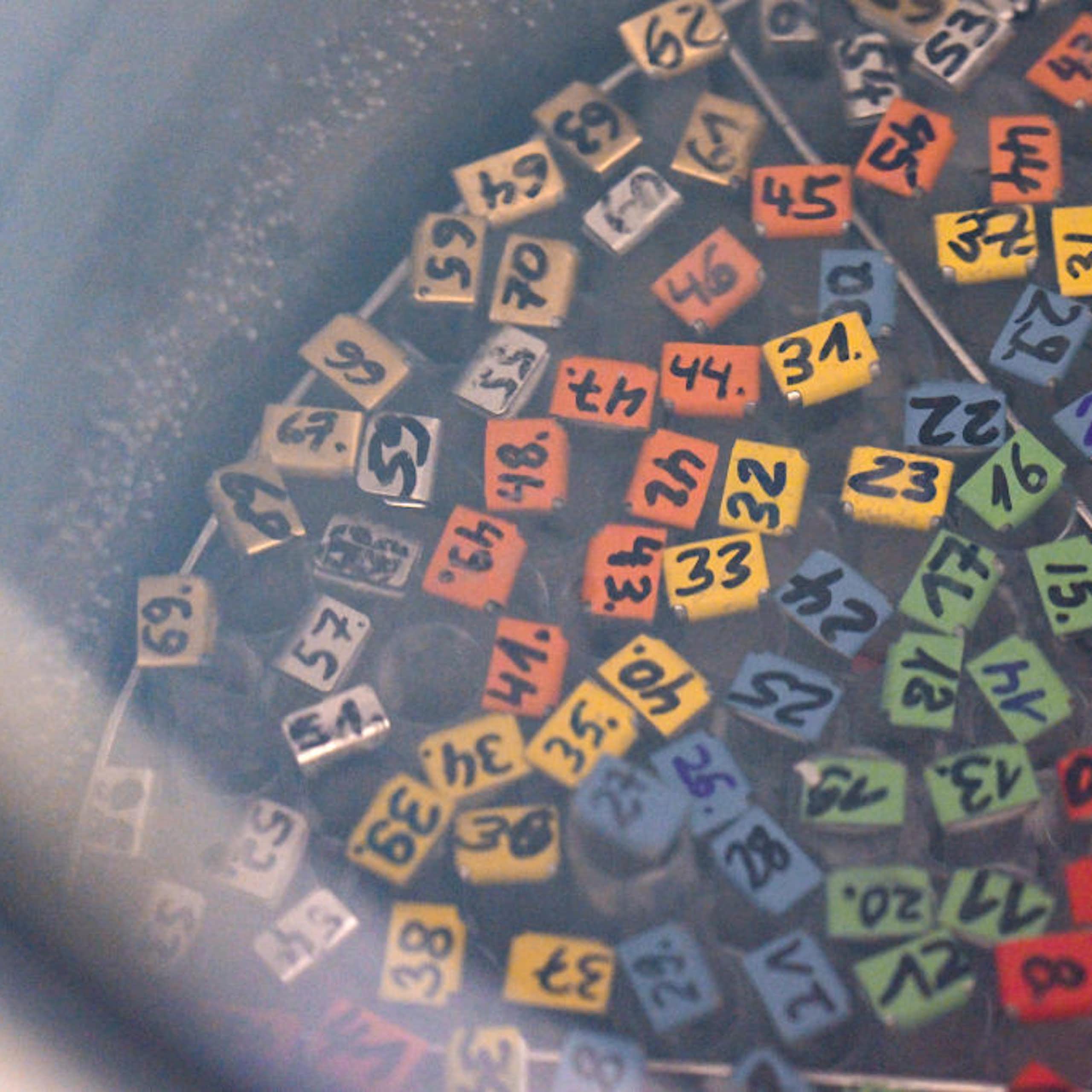Overhead view of the colorful, labeled tops of numbered test tubes in a foggy silver tank