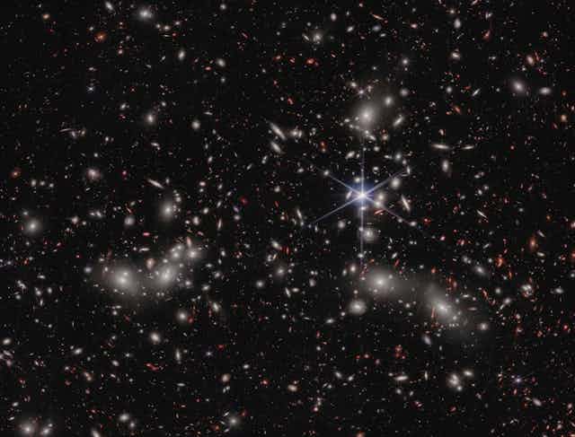 A grayscale image of stars and galaxies in the sky.