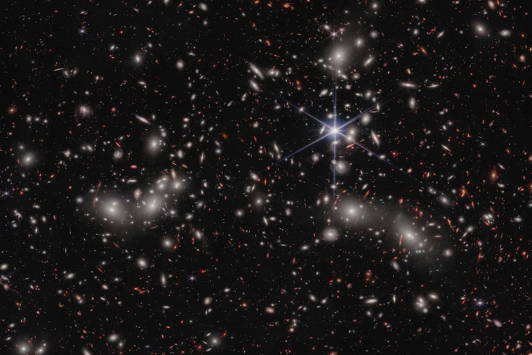 A grayscale image of stars and galaxies in the sky.