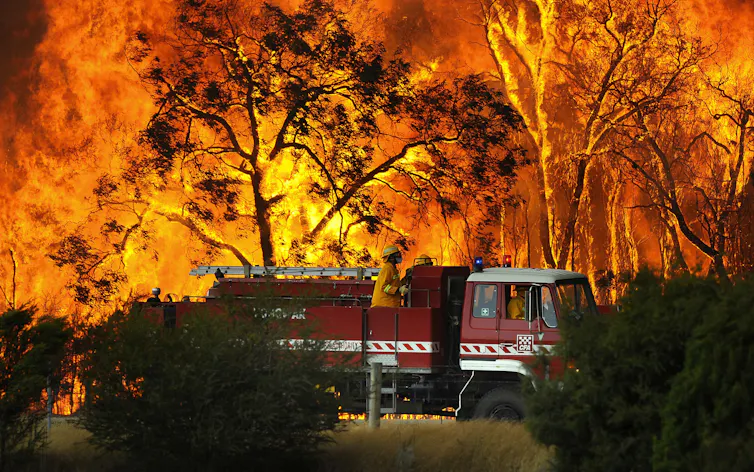 fire rages behind fire truck