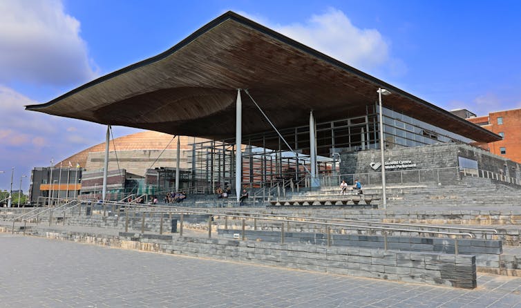 A large modern building with a large roof that juts out.