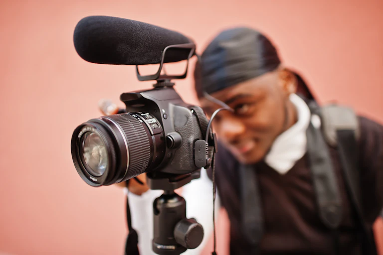 A close-up photograph of a young man using a film camera