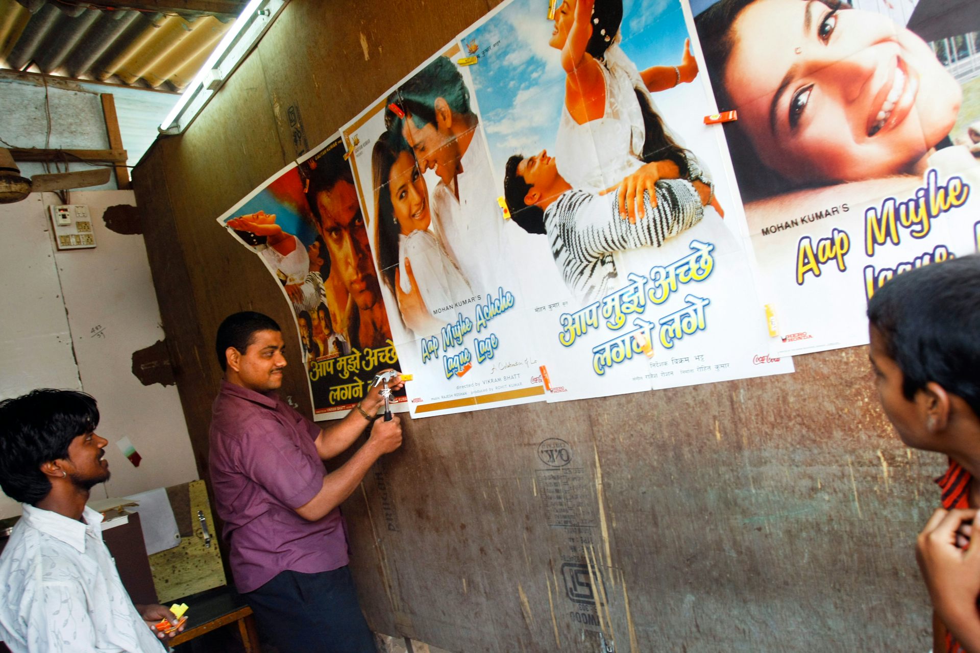 People put up posters on a wall.