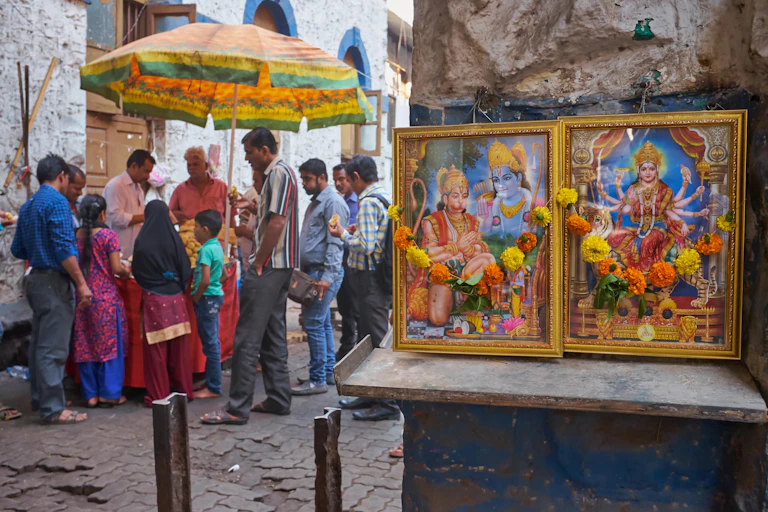 People at a stall with a shrine in the foreground.