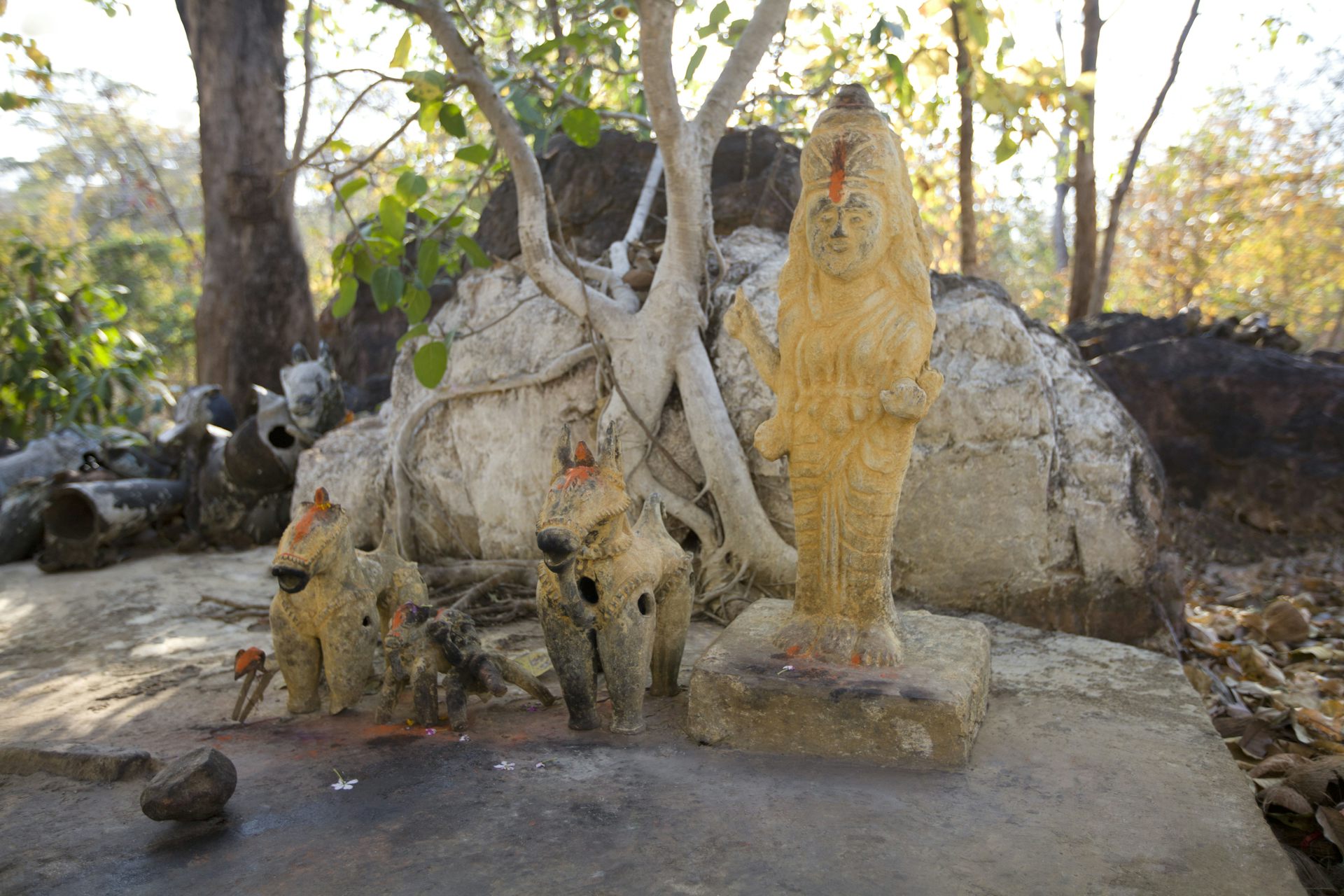 A stone statue in a forest setting.