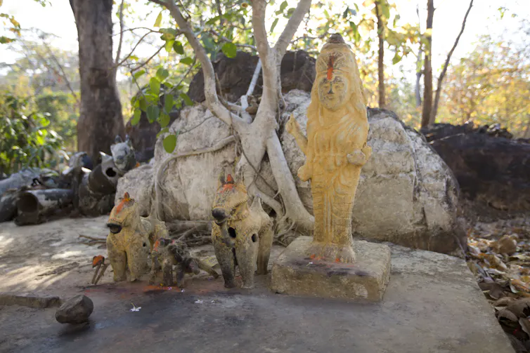 A stone statue in a forest setting.