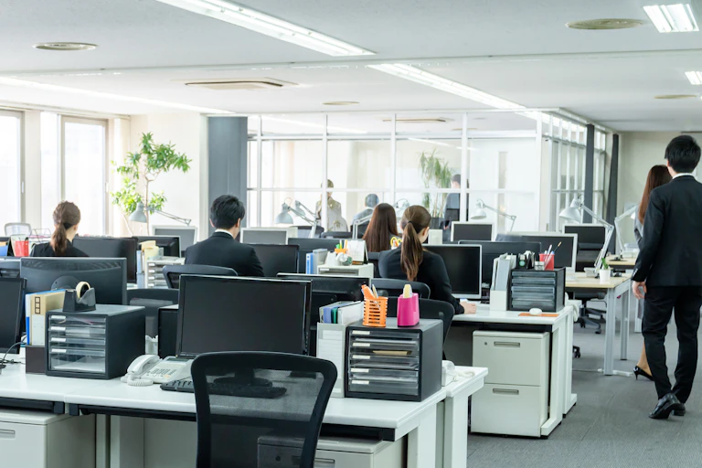 ople sitting with their backs to a workspace