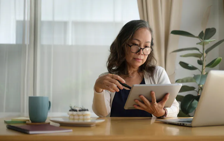 A woman at a desk looking at a tablet
