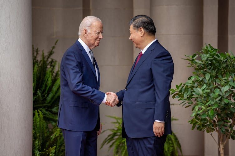 Presidents Biden and Xi shake hands.