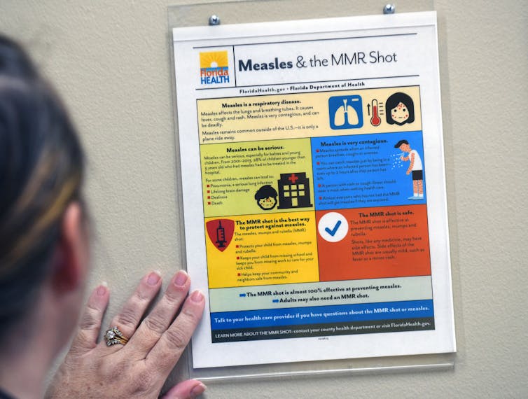 Person looking at Florida Health measles and MMR shot information sheet