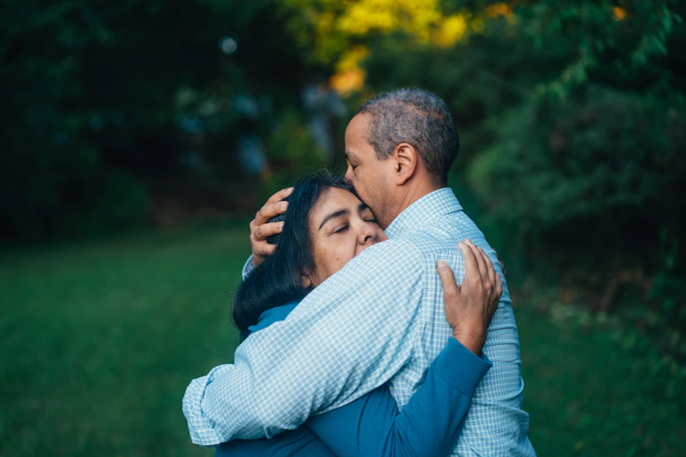 A man and a woman hugging outdoors