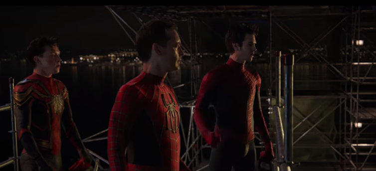 Tres actores diferentes visten el uniforme de Spiderman en una instalación industrial.