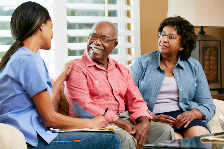 A carer speaks with an elderly couple.